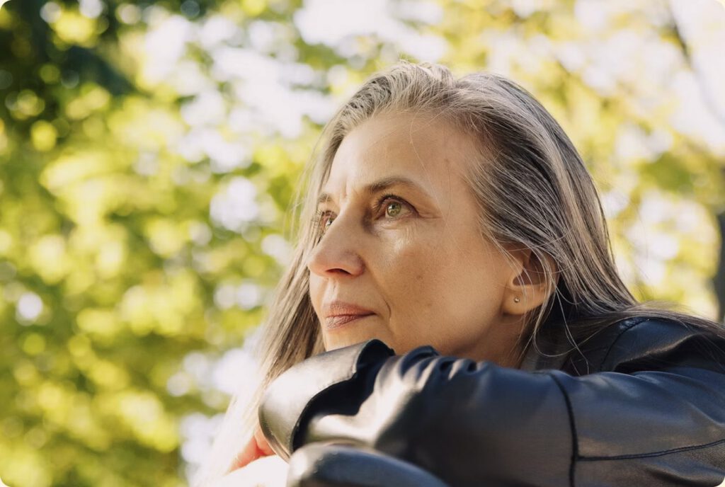 Older woman with grey hair looking into the distance outdoors